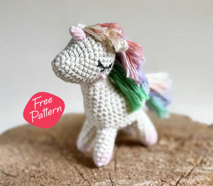 Adorable white amigurumi unicorn with a rainbow mane, a perfect Quick to Make Amigurumi project for magical nursery decor.