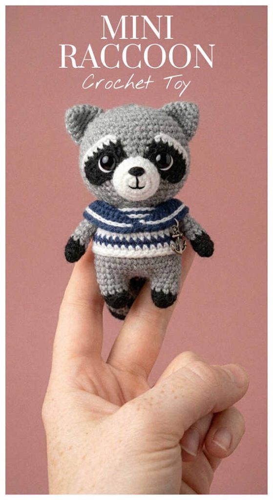 Mini raccoon crochet toy in a striped sweater displayed on a hand