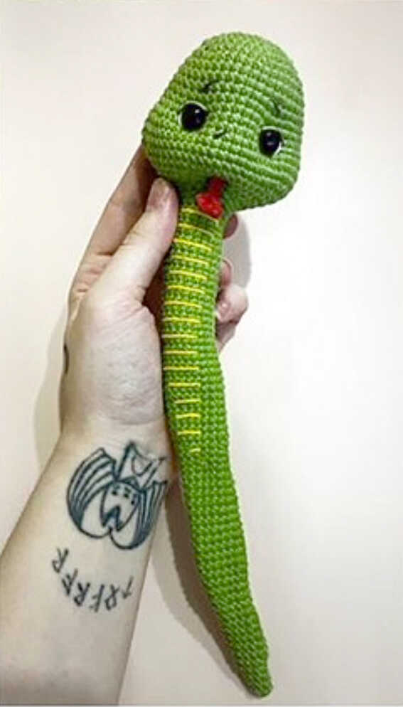 Green snake amigurumi with red tongue and yellow embroidered body stripes
