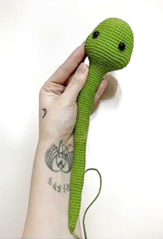 Green snake amigurumi head and long body crocheted before final details